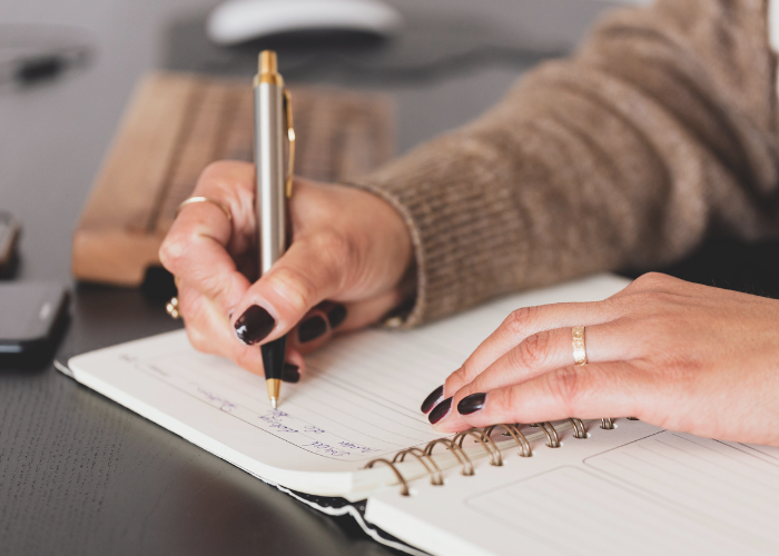 a woman writing in her planner reflecting on her year