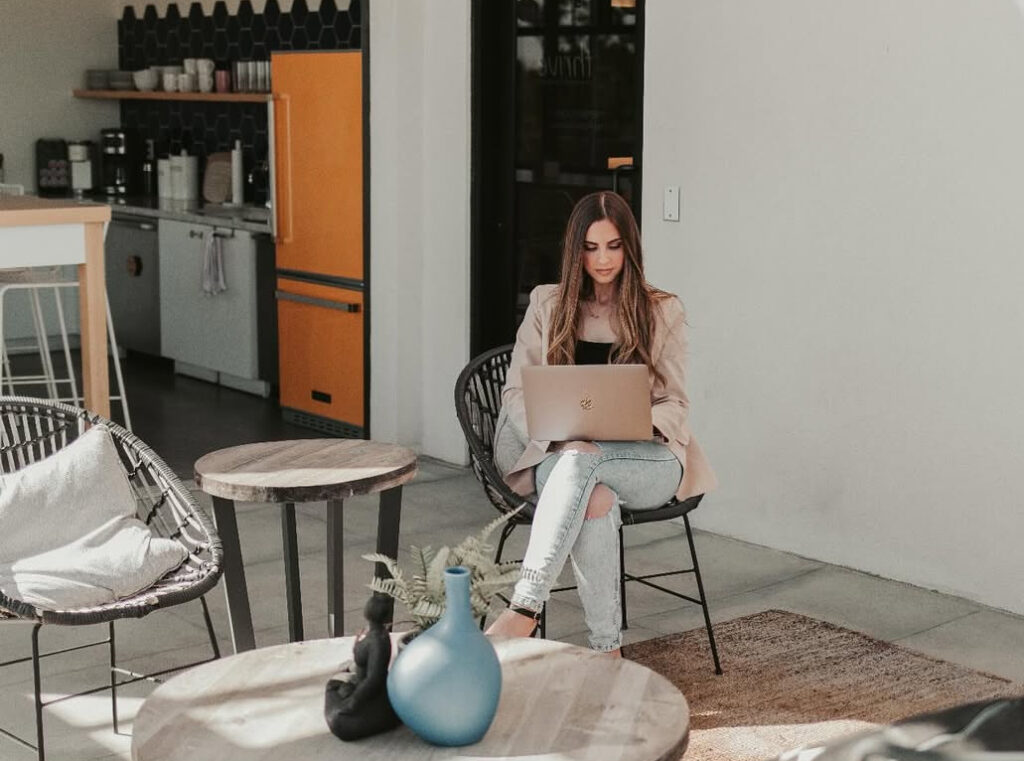A Thrive member works on her laptop in cozy communal area.