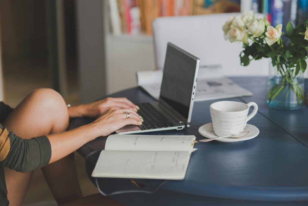 A calm, sunlit workspace with a mug, notebook, and open laptop symbolizing mindful productivity.