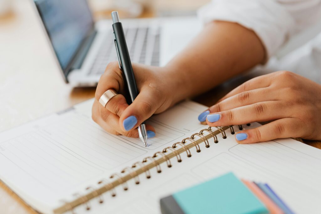 Image of a woman writing in a planner symbolizing decluttering and organizing for the new year.