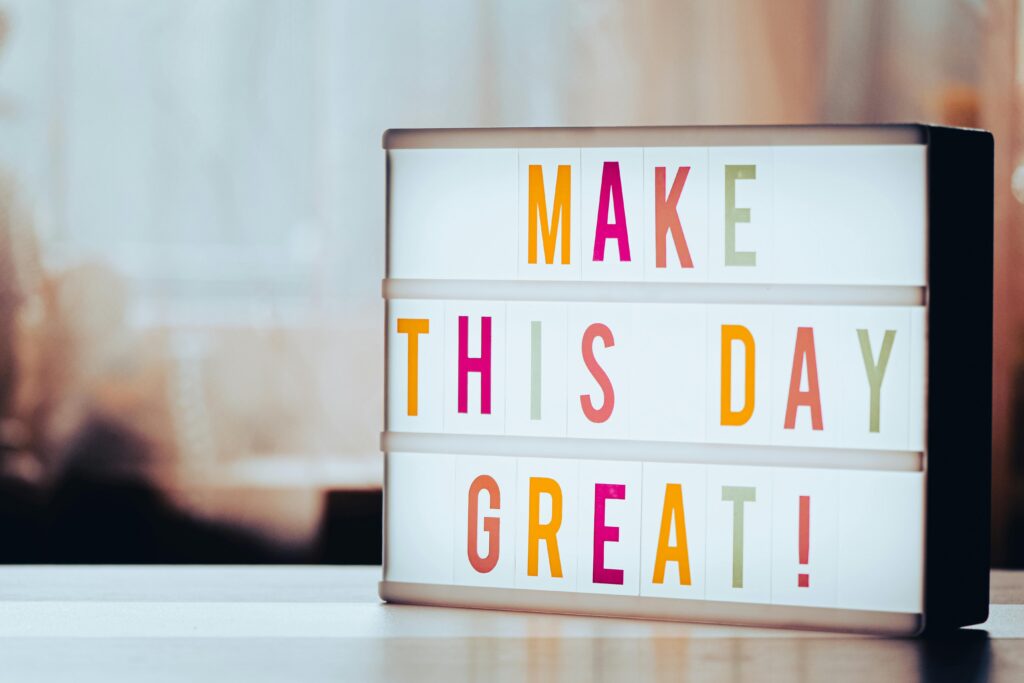 Lightbox sign reading “Make This Day Great” on a desk, symbolizing motivation, fresh starts, and setting goals.