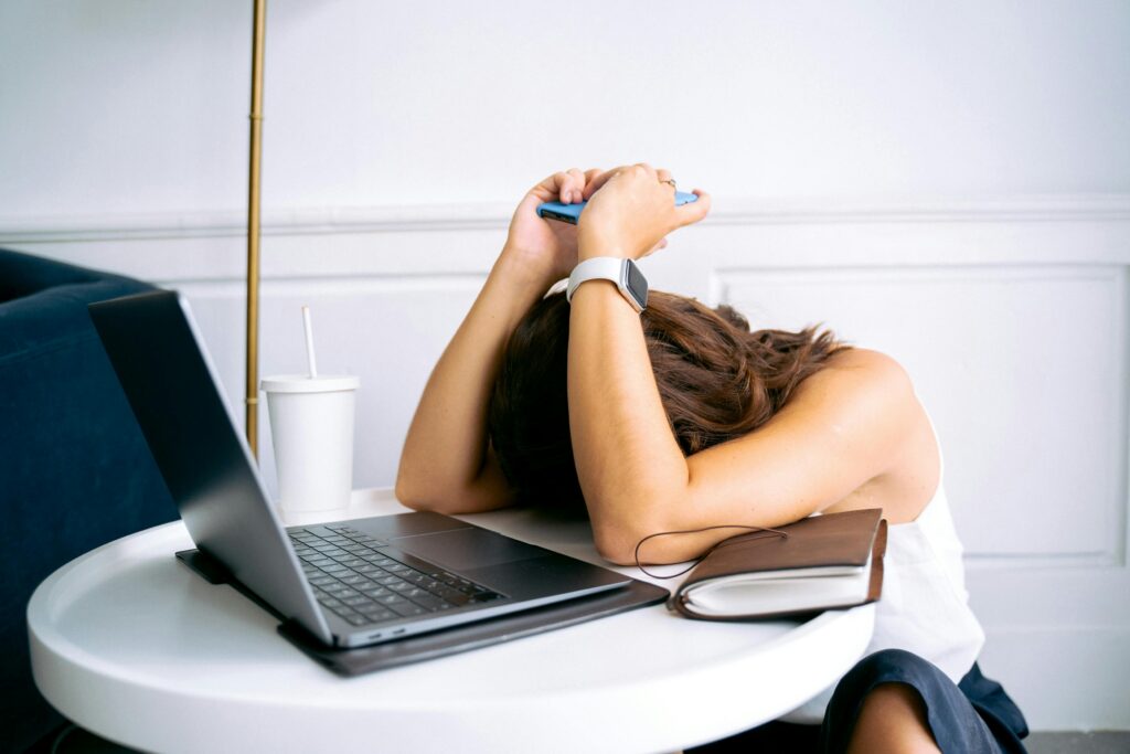 Woman with her head down at her computer, symbolizing feeling stuck. 