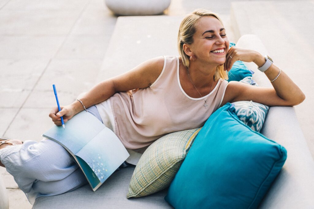 Woman sitting on comfortable couch with a planner.